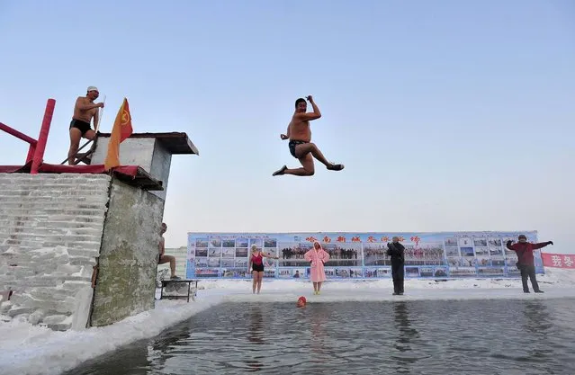 A winter swimmer gestures as he jumps into the icy water of the partially frozen Songhua River in Harbin, China, on December 28, 2013. The temperature in Harbin on Saturday reached as low as minus 5.8 degrees Fahrenheit (– 14.5 °C). (Photo by Sheng Li/Reuters)