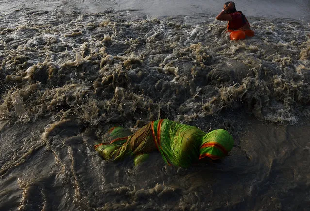 Indian Hindu devotees take a holy bath in the Bay of Bengal at the mouth of the river Ganges in Sagar Island, around 150 km south of Kolkata, on January 13, 2017. (Photo by Dibyangshu Sarkar/AFP Photo)
