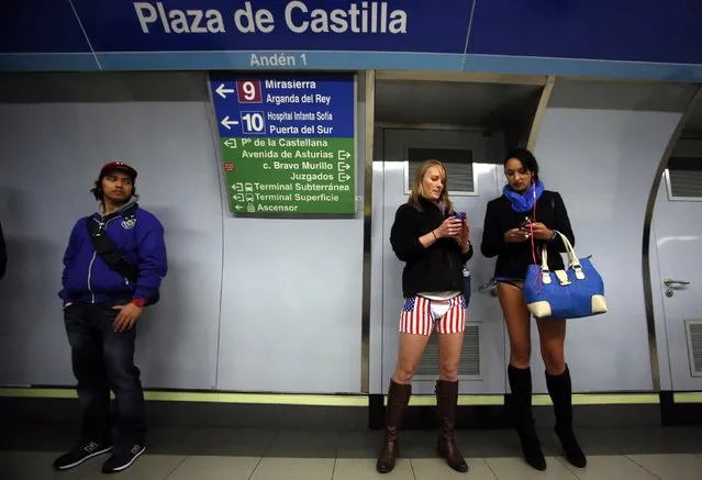 Passengers without their pants check their mobile phones as they wait for a train during the “No Pants Subway Ride” event at Plaza de Castilla subway station in Madrid January 12, 2014. (Photo by Sergio Perez/Reuters)