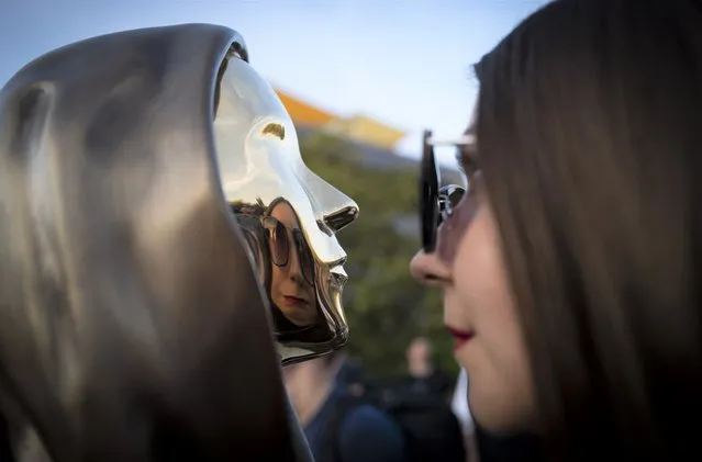 A woman looks at her reflection in a newly unveiled statue of the mysterious developer of the Bitcoin digital currency in Budapest, Hungary, Thursday, September 16, 2021. A bronze statue was unveiled in Hungary’s capital on Thursday which its creators say is the first in the world to pay homage to the anonymous creator of the Bitcoin digital currency. Erected in a business park near the Danube River in Budapest, the bust sits atop a stone plinth engraved with the name of Satoshi Nakamoto, the pseudonym of the mysterious developer of Bitcoin whose true identity is unknown. (Photo by Bela Szandelszky/AP Photo)