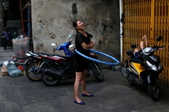 A woman plays with a hula hoop outside her house in Chinatown, Bangkok, Thailand January 24, 2017. (Photo by Jorge Silva/Reuters)