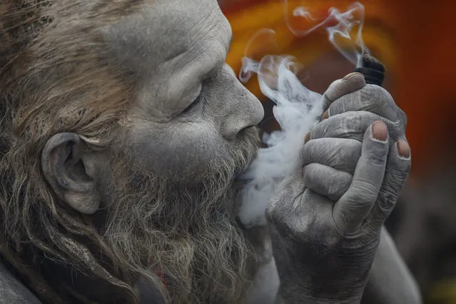 A Hindu Sadhu smokes marijuana from a chillum inside the Pashupatinath Temple premise in Kathmandu, Nepal on March 6, 2016. Holy men from India and Nepal come to celebrate the festival of Maha Shivaratri by smoking, smearing their bodies with ash, offering prayers devoted to the Hindu Deity, Lord Shiva. (Photo by Skanda Gautam via ZUMA Wire)