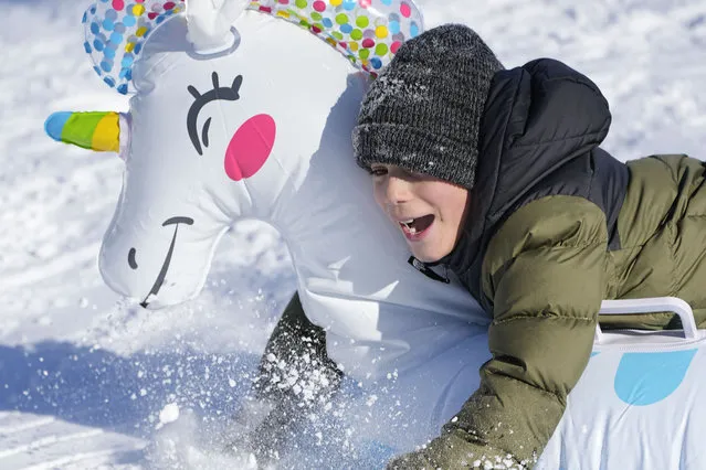 Otis Vanhook smiles as he rides an inflated unicorn down a hill, Tuesday, January 16, 2024, in Nashville, Tenn. A snowstorm blanketed the area with up to eight inches of snow and frigid temperatures. (Photo by George Walker IV/AP Photo)