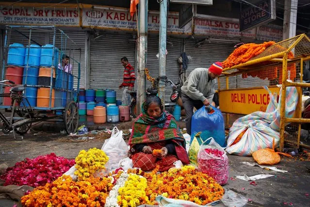A woman makes flower garlands to sell in Old Delhi, India February 1, 2017. (Photo by Cathal McNaughton/Reuters)