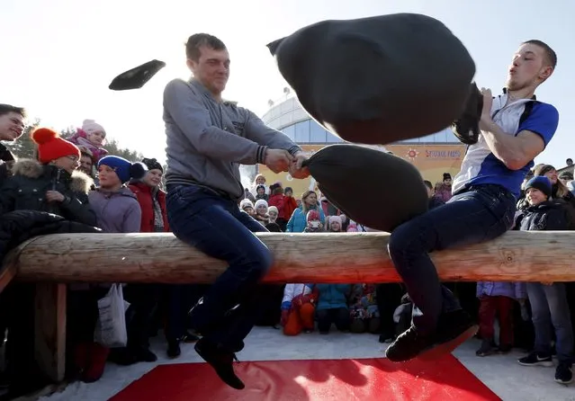 Men take part in a pillow fight contest during Maslenitsa celebrations at the Bobrovy Log ski resort in the suburbs of Krasnoyarsk, Siberia, Russia, March 13, 2016. (Photo by Ilya Naymushin/Reuters)