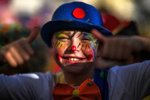 A child dressed up as a clown takes part in the clown parade in Sesimbra on February 12, 2024. (Photo by Patricia De Melo Moreira/AFP Photo)