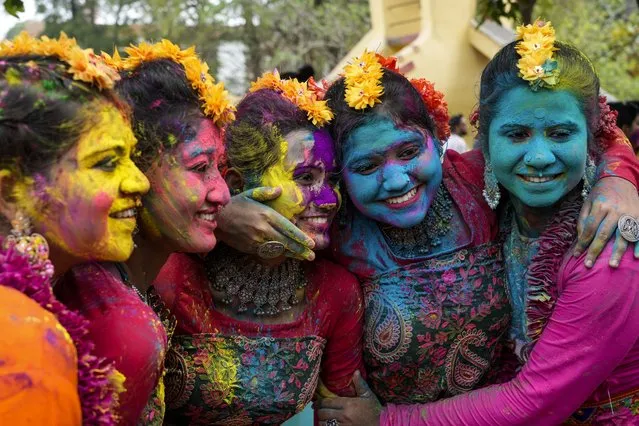 Women, with their faces smeared with coloured powder, pose for a photograph as they celebrate Holi, the festival of colors, in Kolkata, India, Monday, March 25, 2024. (Photo by Bikas Das/AP Photo)