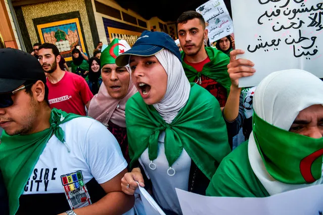 Algerian students draped in national flags shout slogans as they take part in a weekly demonstration in the capital Algiers on May 28, 2019. Algerian media said Monday there was very little chance a presidential election will be held as planned on July 4, after only two candidates – both little known – submitted their candidacies. (Photo by Ryad Kramdi/AFP Photo)