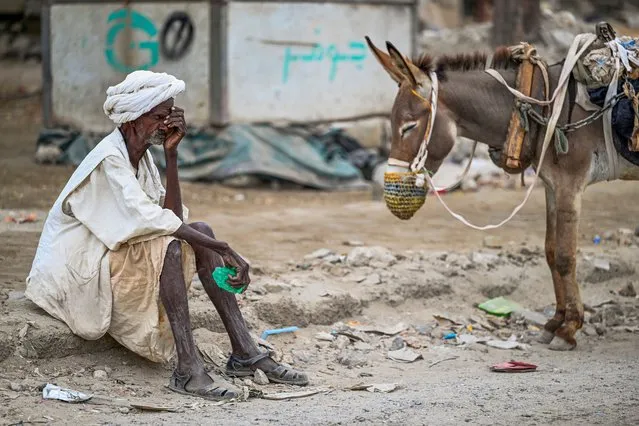 An elderly man waits to refill his donkey-drawn water tank during a water crisis in Port Sudan in the Red Sea State of war-torn Sudan on April 9, 2024. The war between Sudan's army and a paramilitary force since last April has killed tens of thousands and forced millions to flee their homes, in one of the world's most dire humanitarian emergencies. (Photo by AFP Photo/Stringer)