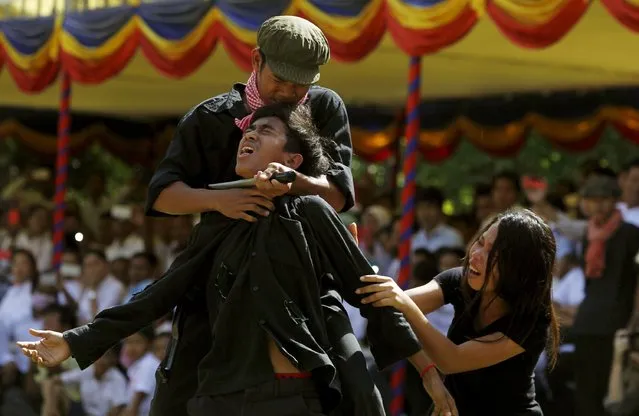 Cambodians perform a play based on the Khmer Rouge regime during the annual “Day of Anger” ceremony at the Choeung Ek “Killing Fields” site, located on the outskirts of Phnom Penh, May 20, 2015. Thousands of Cambodians, including monks, gathered at the site to remember those who perished during the radical communist Khmer Rouge's 1975-79 regime. (Photo by Samrang Pring/Reuters)