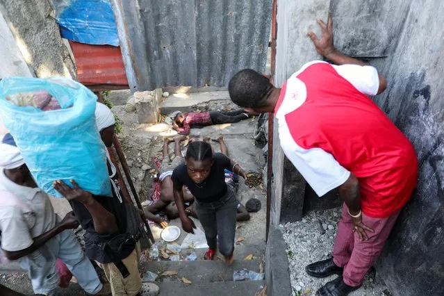 People look at the dead bodies, found in the Petion-Ville suburb, as rival gangs are vying for control of turf, while the state remains largely absent, in Port-au-Prince, Haiti on April 1, 2024. (Photo by Ralph Tedy Erol/Reuters)