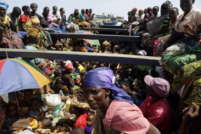 Refugees who fled Burundi's violence and political tension sing in a speedboat taking them to a ship freighted by the UN, at Kagunga on Lake Tanganyika, Tanzania, Saturday, May 23, 2015 to be taken to the port city of Kigoma. (Photo by Jerome Delay/AP Photo)