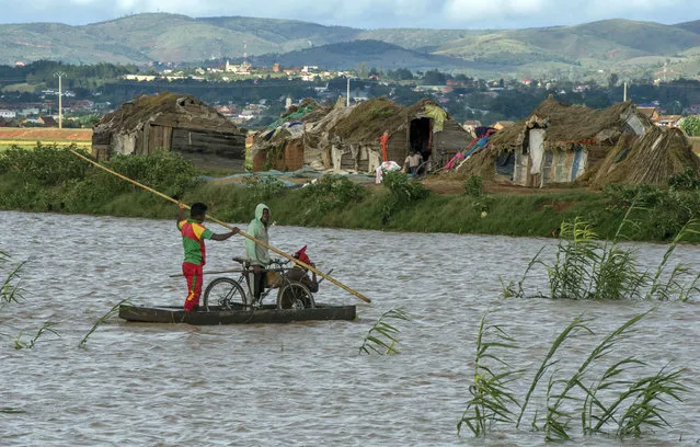 Residents cross flooded fields in Madagascar's capital Antananarivo, on Thursday, March 9, 2017. Officials in Madagascar say the death toll from Cyclone Enawo has risen to at least five and about 10,000 people have left their homes because of storm damage. (Photo by Alexander Joe/AP Photo)