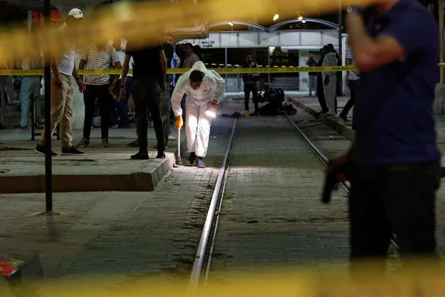 Onlookers gather at the scene outside a metro station where a man reportedly wearing an explosive belt blew himself up in the early hours of July 3, 2019 in the capital Tunis, after being chased by police. The Tunisian interior ministry said a jihadist, on the run for two days, was killed on July 3 in the western Tunis neighbourhood of Cité Intilaka while security forces were chasing him to detain him. The official sources said the suspect blew himself up during the police operation. (Photo by Zoubeir Souissi/Reuters)