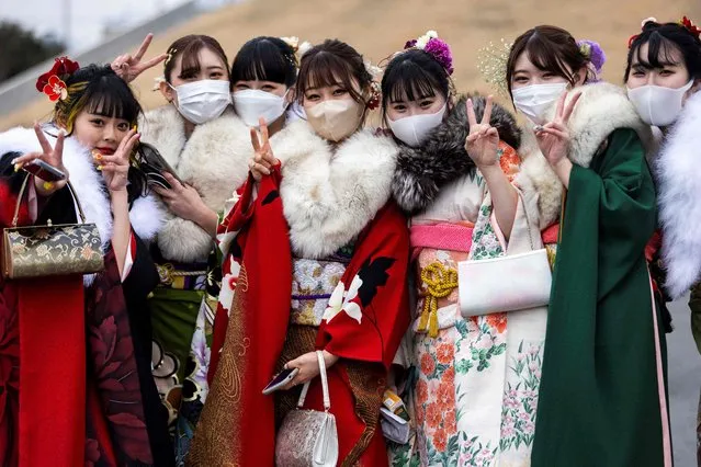 Twenty-year-old women dressed in kimonos pose outside Todoroki Arena during a celebration ceremony to mark “Coming-of-Age Day” to honour people who turn 20 this year to signify adulthood, in Kawasaki, Kanagawa prefecture on January 10, 2022. (Photo by Behrouz Mehri/AFP Photo)