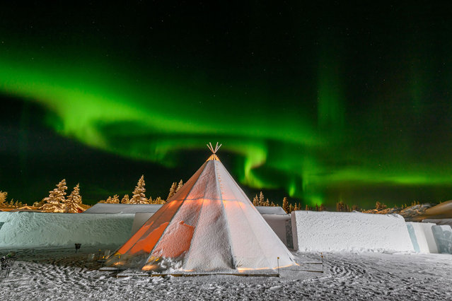 A view of a Tipi set up next tothe entrance of Icehotel 34 with the Northern Lights or Aurora Borealis over it on December 16, 2023 in Jukkasjarvi, Sweden. Since 1989, the Icehotel – part hotel, part art exhibition – has been crafted annually from ice taken from the Torne River. (Photo by Roy Rochlin/Getty Images)