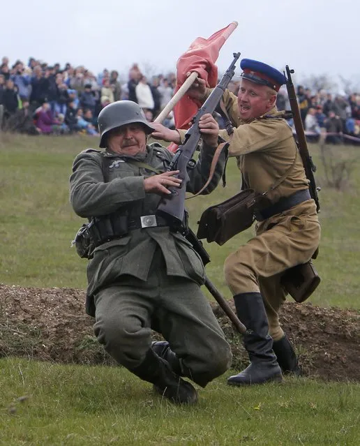 People, depicting soldiers, take part in a costumed reconstruction performance dedicated to the 70th anniversary of the liberation of Simferopol from fascist troops during the World War Two outside of the village of Kurtsy near Simferopol in Crimea April 13, 2014. (Photo by Maxim Shemetov/Reuters)