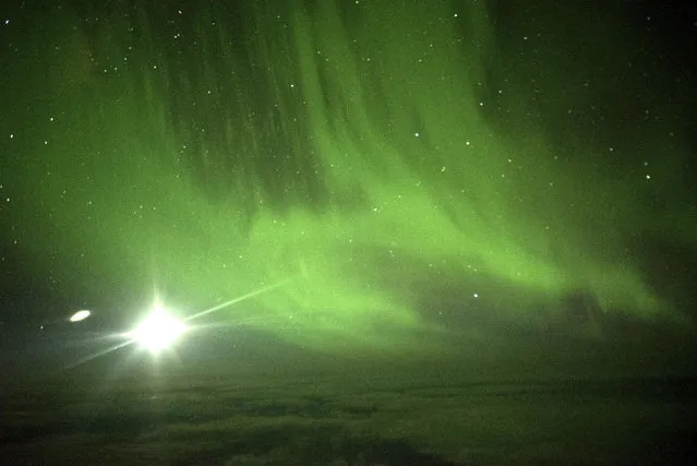 The Southern Lights are seen over the Southern Ocean near Antarctica from a chattered plane Friday, March 24, 2017. A charter plane that left Dunedin, New Zealand, late Thursday flew close to the Antarctic Circle to give the eager passengers an up-close look at the Aurora Australis, or Southern Lights. (Photo by Ian Griffin via AP Photo)