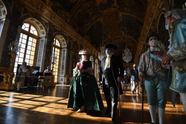 Guests dressed in baroque period costumes attend the opening of the “Night Fountains Show” (“Grandes Eaux Nocturnes”) and the “Royal Serenade” events in the Hall of Mirrors of the Royal Palace of Versailles, in Versailles, outskirts of Paris, on June 12, 2021. (Photo by Alain Jocard/AFP Photo)