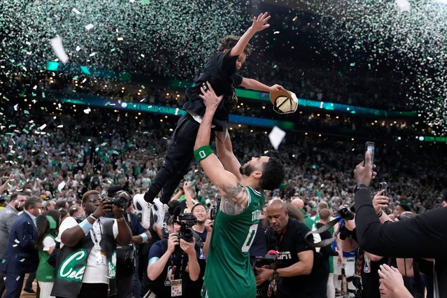 Boston Celtics forward Jayson Tatum (0) lifts his son Deuce as he celebrates with the team after the Celtics won the NBA basketball championship with a Game 5 victory over Dallas Mavericks, Monday, June 17, 2024, in Boston. (Photo by Charles Krupa/AP Photo)