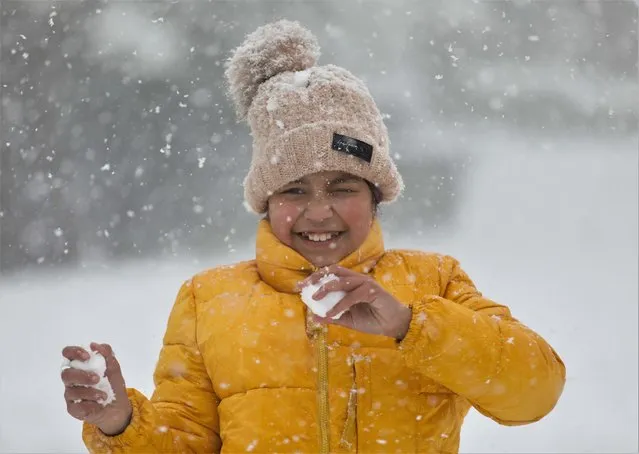 A girl reacts as she plays during a snowfall at Chandragiri Hills above the Kathmandu valley, Nepal, December 29, 2021. (Photo by Navesh Chitrakar/Reuters)