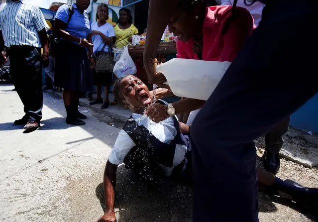 A student affected by tear gas is helped during clashes between students and the national police in Port-au-Prince, Haiti, on May 7, 2014. Students are demanding that authorities respond to their striking teachers' demands for higher pay and improved working conditions. Students are concerned they will not be able to take exams which allow them to move on to the next level. (Photo by Dieu Nalio Chery/Associated Press)