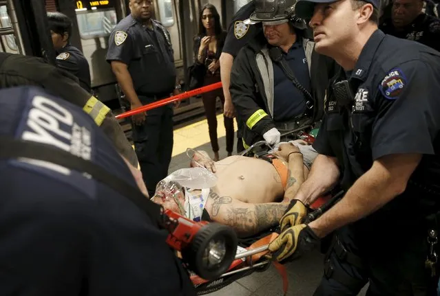 New York City Police and Fire Department emergency workers remove an injured man from a subway platform after he was apparently struck by a southbound “N” subway train in the Times Square station in New York City, July 17, 2015. (Photo by Mike Segar/Reuters)