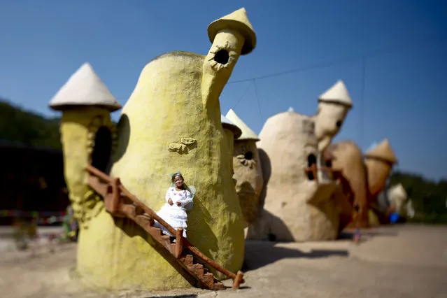 A picture made with a tilt-shift lens shows “Dwarf Empire” cast member 19-year-old Han Zhen Yan posing in her fairy costume backstage outside one of the fairy tale-like houses at the Dwarf Empire theme park outside Kunming, China's Yunnan province, 04 April 2013. (Photo by Diego Azubel/EPA)