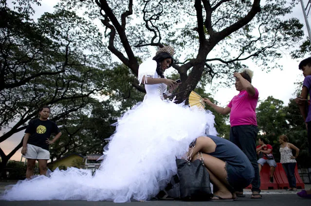 A participant in a white dress receives assistance as Association of Transgender People in the Philippines (ATP) and TransMan Philippines (TMP) members prepare to participate in a “Santacruzan” procession in Manila on May 18, 2014. The parade is held in celebration of the International Day Against Homophobia and Transphobia. (Photo by Noel Celis/AFP Photo)