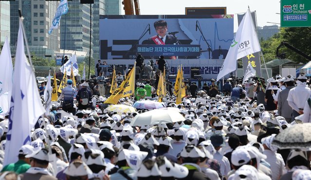 Lim Hyun-taek (C), president of the Korea Medical Association (KMA), appears on a screen as he delivers a speech during a rally  to protest against an increase in medical student enrollment, in Seoul, South Korea, 18 June 2024. The rally takes place amidst a nationwide one-day walkout by community doctors belonging to the Korean Medical Association protesting a hike in medical student enrollment. (Photo by Yonhap/EPA)