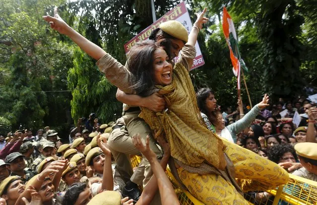 A policewoman tries to stop a member of the All India Mahila Congress, the women's wing of the Congress party, who was trying to cross over a barricade, during a protest against Indian Prime Minister Narendra Modi in New Delhi, India, July 21, 2015. India's parliament was adjourned on the first day of a new session after opposition lawmakers demanded the resignation of leaders tainted by corruption allegations, deepening an impasse that has stalled the government's reform agenda. (Photo by Adnan Abidi/Reuters)