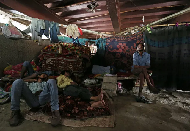 People watch a movie in a makeshift cinema located under a bridge in the old quarters of Delhi, India May 25, 2016. (Photo by Cathal McNaughton/Reuters)