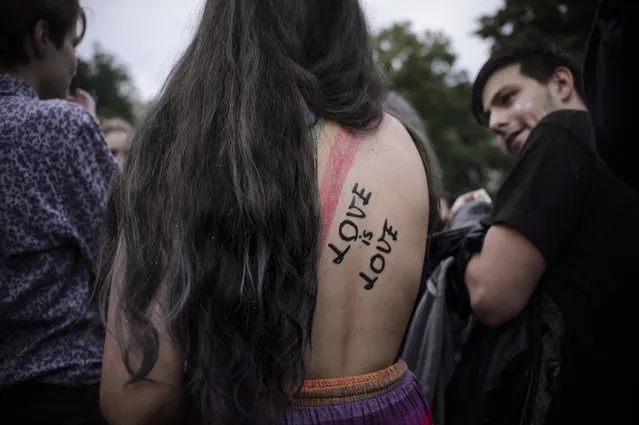 A young woman with a rainbow flag and the text “Love is Love” painted on her back takes part in a Gay Pride Parade in Bucharest, Romania, Saturday, May 20, 2017. Some 1,000 people have joined a gay pride march in the Romanian capital of Bucharest on Saturday, demanding greater rights amid government moves they say will curtail their human rights. (Photo by Andreea Alexandru/AP Photo)