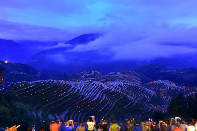 People take pictures of thousands of torches placed in terraced fields during a local festival praying for good harvest at Guilin, Guangxi Zhuang Autonomous Region, China June 2, 2017. (Photo by Reuters/Stringer)