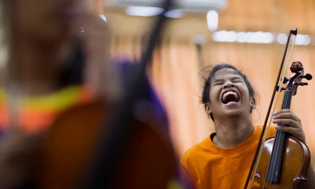 Blind Thai student Kanya Phu-ard, aged 12, a member of the Thai Blind Orchestra, burst into laughter during a band rehearsal at the “School for the Blind and the Blind with Multi-Handicapped” in the city of Lopburi province, Thailand, 12 May 2016. The Thai Blind Orchestra was established in 2014 and is made up of young musicians aged between 9 and 18 years who are blind, visually impaired and/or multiple disabled. (Photo by Rungroj Yongrit/EPA)