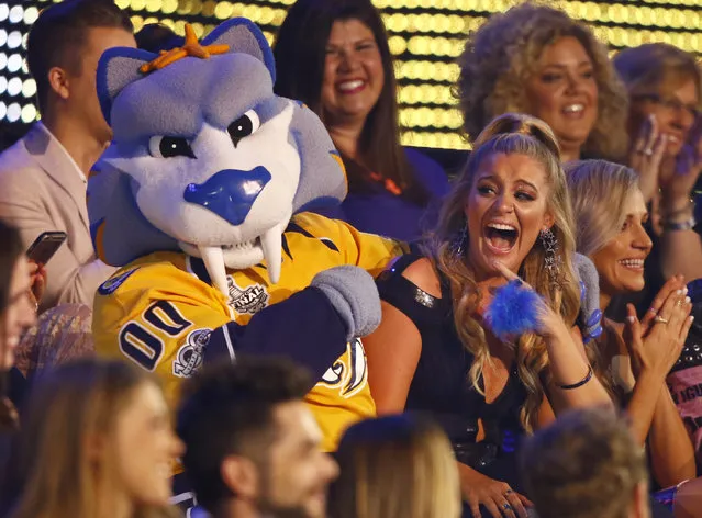Lauren Alaina sits in the audience with Gnash, the mascot for the NHL's Nashville Predators, at the CMT Music Awards at Music City Center on Wednesday, June 7, 2017, in Nashville, Tenn. (Photo by Wade Payne/Invision/AP Photo)