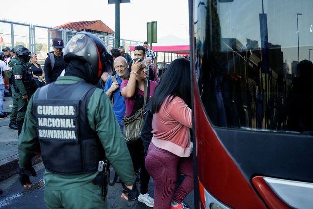 Members of the Bolivarian National Guard help people get on a bus during a power outage affecting Caracas and other regions of the country, in Caracas, Venezuela on August 30, 2024. (Photo by Leonardo Fernandez Viloria/Reuters)