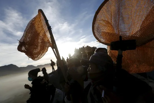 Villagers holds their nets as they wait for Hindu worshippers to throw their offerings into the crater during the Kasada Festival at Mount Bromo in Probolinggo, Indonesia's East Java province, August 1, 2015. (Photo by Reuters/Beawiharta)