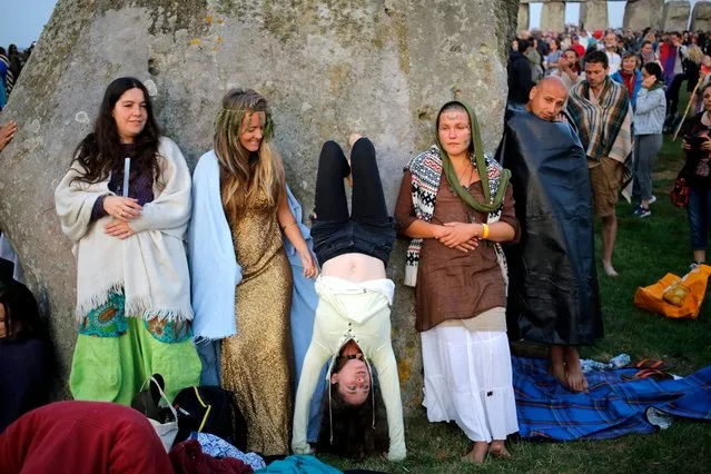 Revelers wait for the sun to rise on the summer solstice during the annual festival at Stonehenge, Salisbury, Britain, 21 June 2017. (Photo by Kim Ludbrook/EPA)