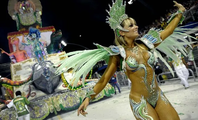 A reveller of the Mancha Verde samba school dances in front of a float at the Sambadrome