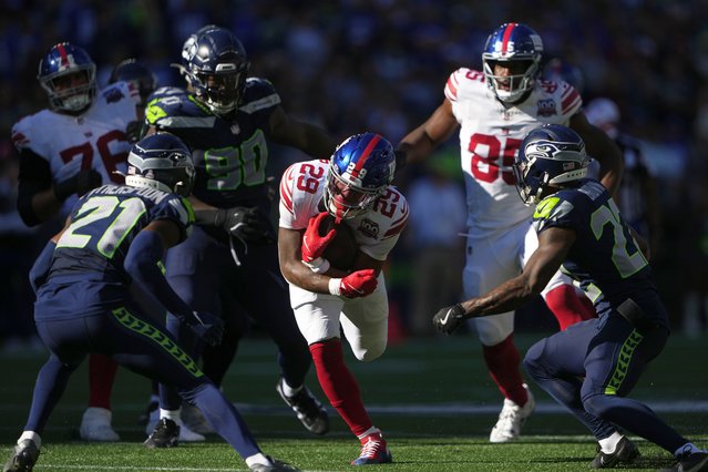 New York Giants running back Tyrone Tracy Jr. (29) runs with the football as Seattle Seahawks cornerbacks Devon Witherspoon (21), left, and Tre Brown (22), right, look to tackle during the second half of an NFL football game, Sunday, October 6, 2024, in Seattle. (Photo by Lindsey Wasson/AP Photo)