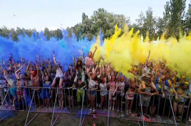 Youth throw blue and yellow powder, the colours of Ukrainian national flag, at each other during the Festival of Colours in Kiev, Ukraine, June 25, 2016. (Photo by Valentyn Ogirenko/Reuters)