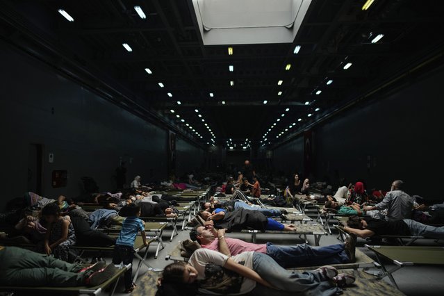 People, mostly Turkish citizens, rest on board of a Turkish military ship evacuating them from Lebanon to Turkey, in Beirut port, on Thursday, October 10, 2024. (Photo by Emrah Gurel/AP Photo)