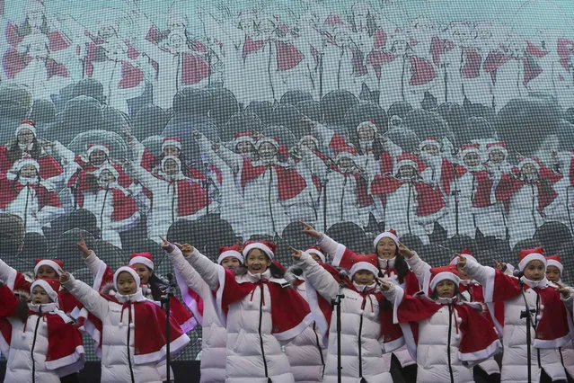 Children sing carols during a Christmas charity event as they gather to deliver gifts for the poor in Seoul, South Korea, Tuesday, December 24, 2019. (Photo by Ahn Young-joon/AP Photo)
