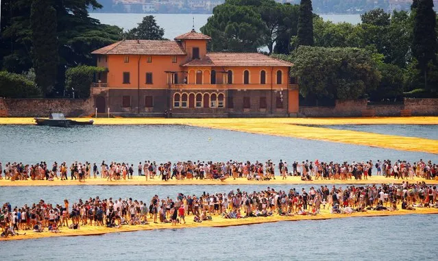 People walk on the installation “The Floating Piers” on Lake Iseo by Bulgarian-born artist Christo Vladimirov Yavachev, known as Christo, at the installation's last weekend near Sulzano, northern Italy, July 2, 2016. (Photo by Wolfgang Rattay/Reuters)