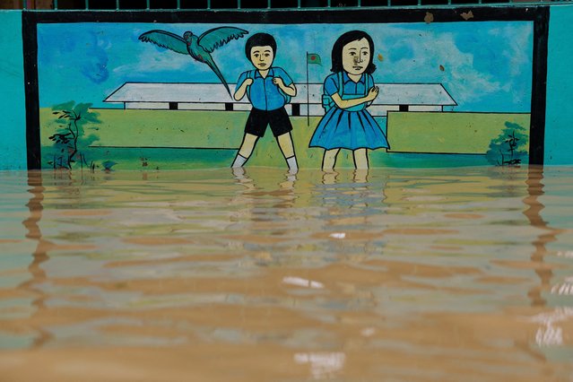 A painting on the wall of a school submerged in flood water is seen amid severe flooding in the Fazilpur area of Feni, Bangladesh on August 26, 2024. (Photo by Mohammad Ponir Hossain/Reuters)