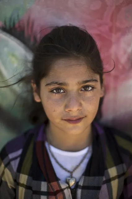 In this Tuesday, July 29, 2014 photo, Syrian refugee Yasmeen, 9, poses for a picture at Zaatari refugee camp, near the Syrian border, in Mafraq, Jordan. (Photo by Muhammed Muheisen/AP Photo)