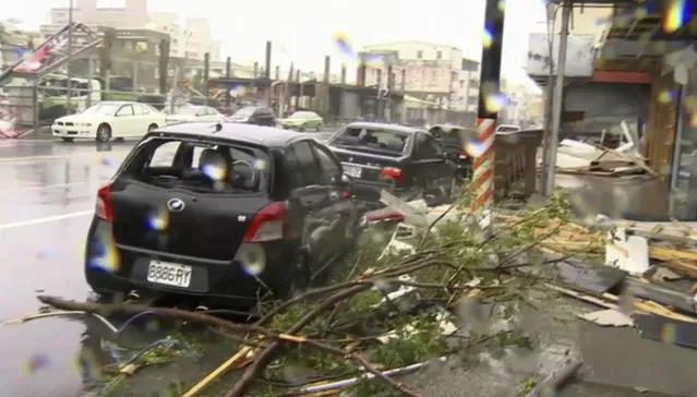 In this image made from video, wind-blown debris from Typhoon Nepartak litters the street and damages a vehicle in Taitung, south eastern Taiwan, Friday, July 8, 2016. Power was partially restored in Taiwan on Friday after Nepartak slammed into the island's eastern coast with ferocious winds and torrential rains. (Photo by EBC via AP Video)