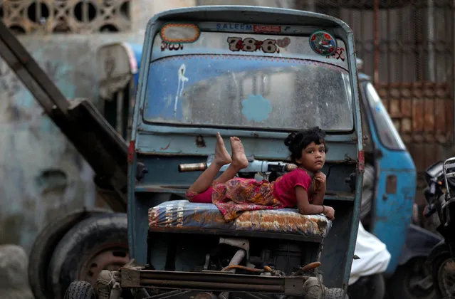 A girl rests on a rickshaw (parked along a street in Karachi Pakistan July 13, 2017. (Photo by Akhtar Soomro/Reuters)