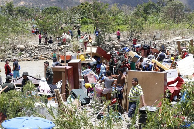 People with their belongings arrive in Colombia after crossing the Tachira river border with Venezuela, near Villa del Rosario village August 25, 2015. (Photo by Jose Miguel Gomez/Reuters)